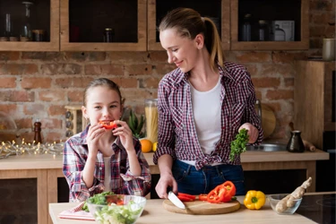 Daughter helping mom prepare a meal